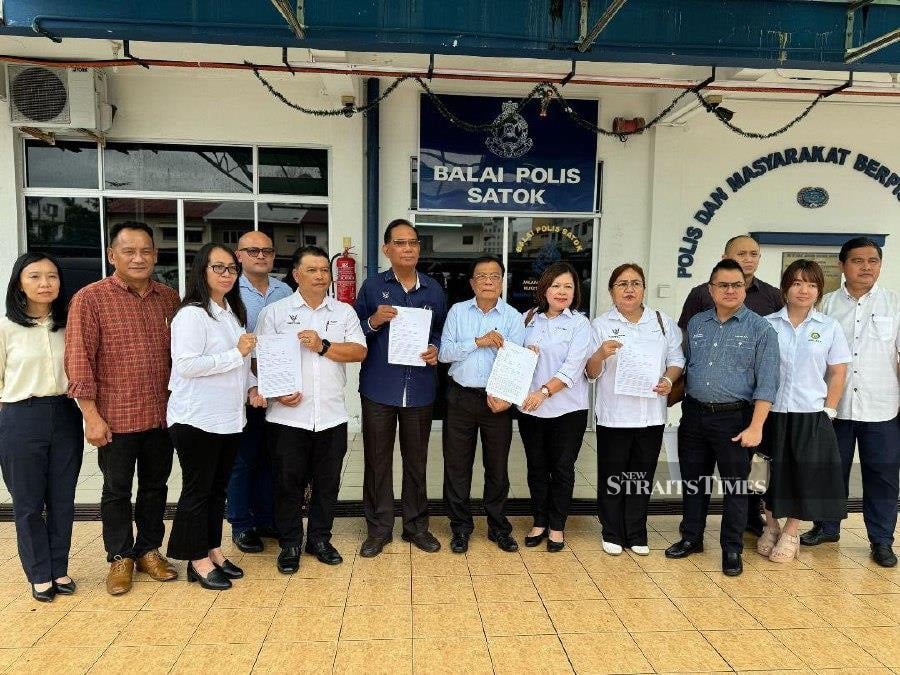 John Nyigor (seventh from left) and his political secretaries colleague show copies of the police reports they made against vlogger Zool Amali Hussin or popularly known by his online pen name Bozz Jebat. STR/BRUNO J