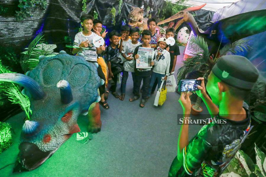 The public did not miss the opportunity to visit the dinosaur tunnel or Dino Land at The New Straits Times Press (NSTP) (M) Bhd's booth during the Jom Heboh Carnival at the Batu Kawan State Stadium here. -NSTP/DANIAL SAAD