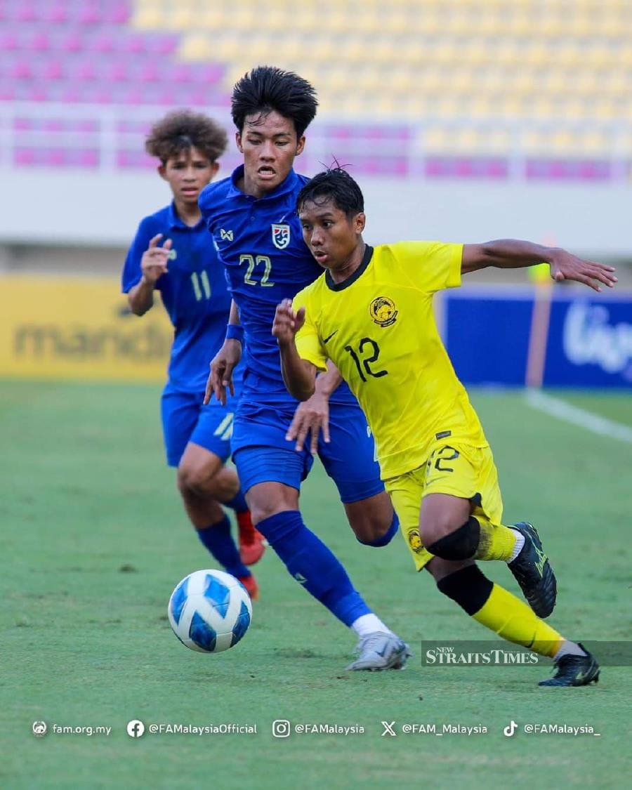 A Malaysian player (in yellow) is guarded by two Thai players during an Asean Under-16 championship match at Surakarta Stadium, Indonesia, today. Pic from FAM 