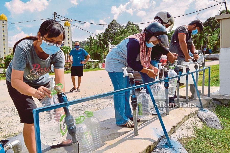 People filling up containers with water from public taps provided by Air Selangor outside Masjid Jamek Ar Rahimiah in Klang following water supply disruptions in October 2020.  - NSTP file pic