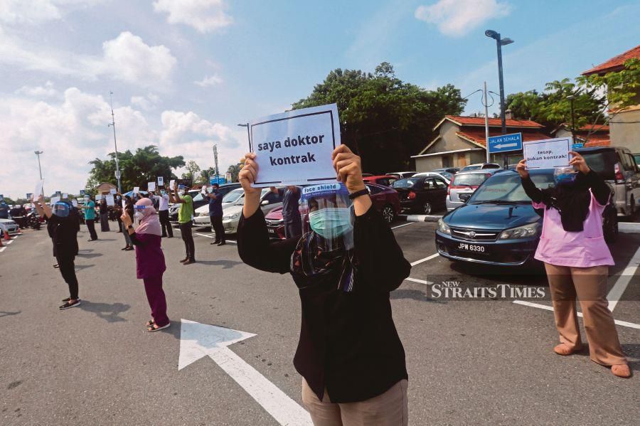 Contract doctors participating in the Hartal Doktor Kontrak  outside Melaka Hospital on Monday.   PIC BY SYAFEEQ AHMAD