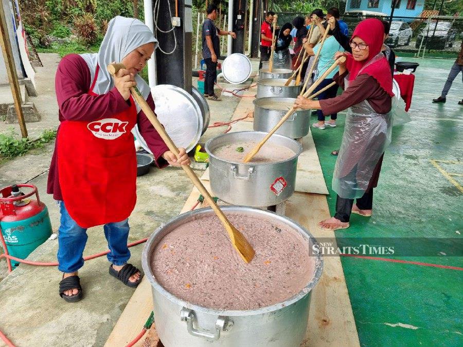 Desa Cinta Kobuni Homestay operators preparing the Sabah-style Ramadan bubur lambuk using red hill rice. Pic by Paul Mu