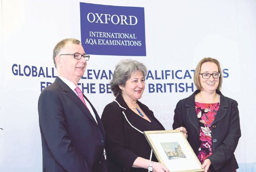 British High Commissioner to Malaysia Victoria Treadell (centre) receiving a token of appreciation from Oxford International AQA Examinations Managing Director Christine Ozden as Andrew Hall looks on.