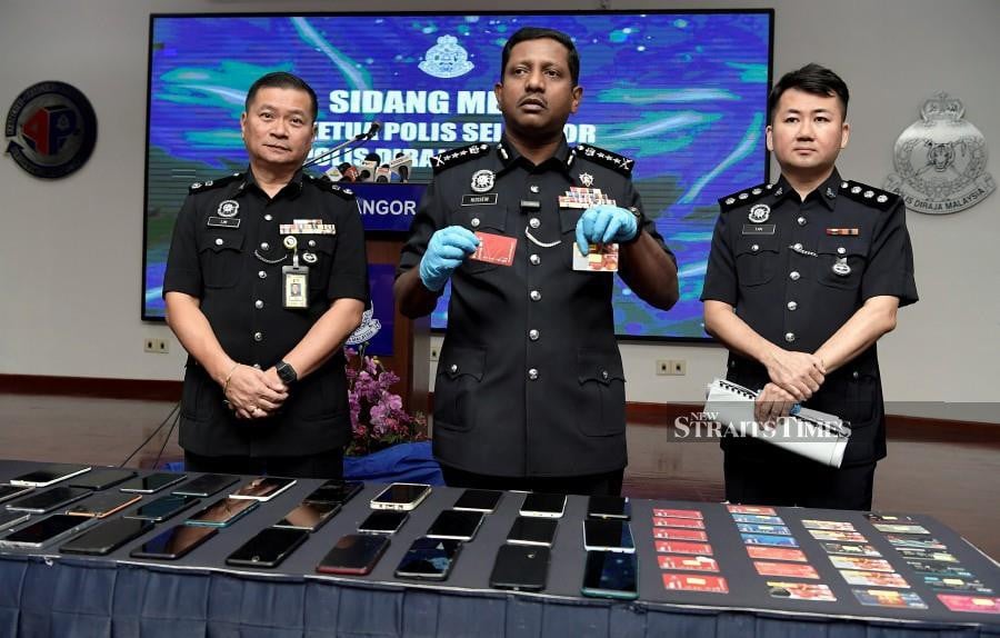 Selangor police chief Datuk Hussein Omar Khan (centre) showing the bank cards seized in a recent case involving a syndicate selling bank accounts and distributing automated teller machine (ATM) cards. 
