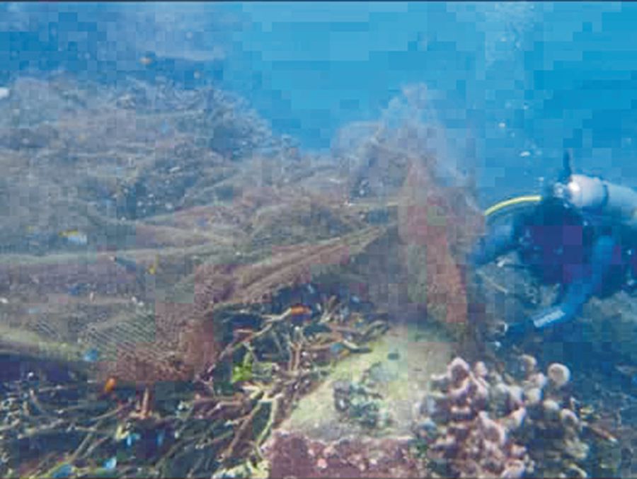  A diver removing a ghost net stuck on a reef. PIC COURTESY OF REEF CHECK MALAYSIA