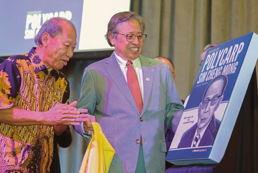 Sarawak Premier Tan Sri Abang Johari Openg launching the biography of Datuk Polycarp Sim Cheng Mong in Kuching last Wednesday. With him is author Richard Song Swee Jin. BERNAMA PIC 