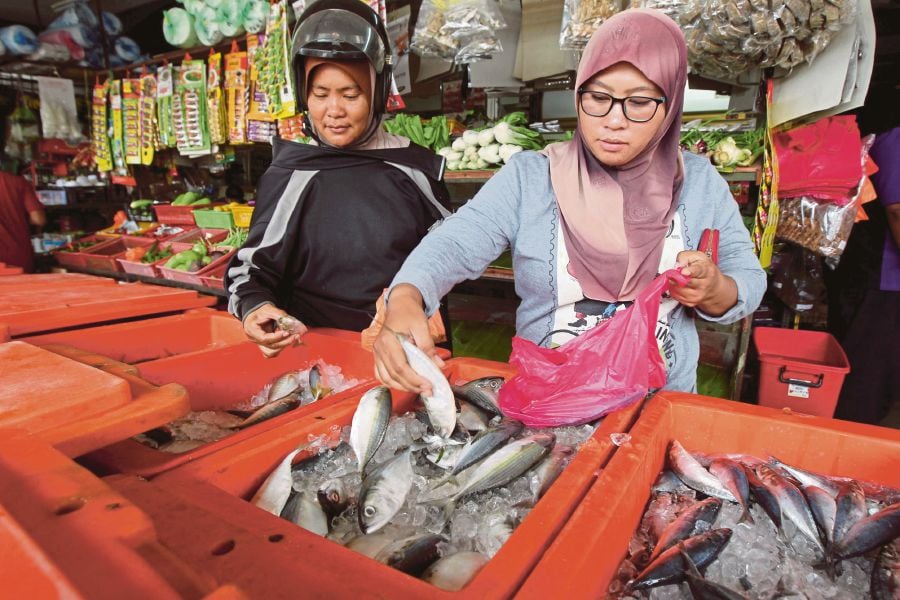 Women buying fish at a wet market in Klang. The International Monetary Fund has heaped praise on the government and Bank Negara Malaysia for their handling of the country’s economy and monetary policy. FILE PIC
