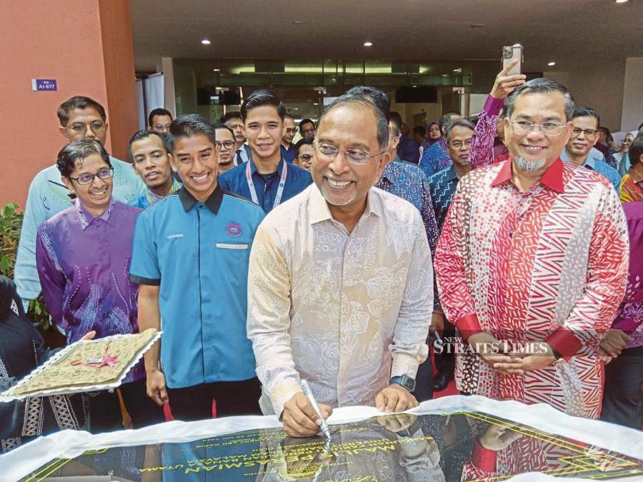 Higher Education Minister Datuk Seri Dr Zambry Abd Kadir signing a plaque after opening the Universiti Sains Islam Malaysia Language Studies Faculty building. NSTP/MOHD AMIN JALIL
