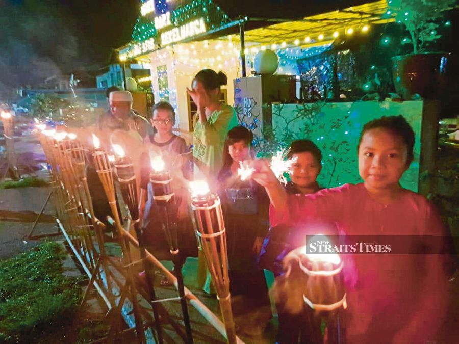 Lighting the lamps at the start of Malam Tujuh Likur indicates that Hari Raya is near. PIC BY MOHD RADZI BUJANG