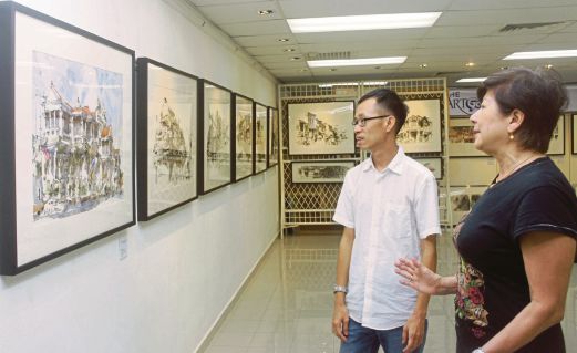 Ch'ng Kian Kiean and Datin Ivy Lee view the pieces to be shown in the exhibition opening on Sunday.