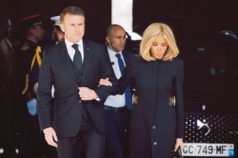  French President Emmanuel Macron and his wife, Brigitte, attending an event in Paris this month. Brigitte is taking legal action against those behind the transgender allegations. AFP PIC 