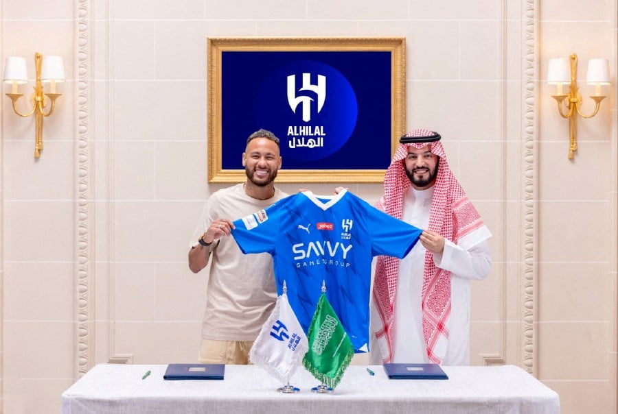 Al Hilal's new signing Neymar holds their shirt as he poses with President Fahd bin Saad Al-Nafel in Paris. - REUETRS PIC