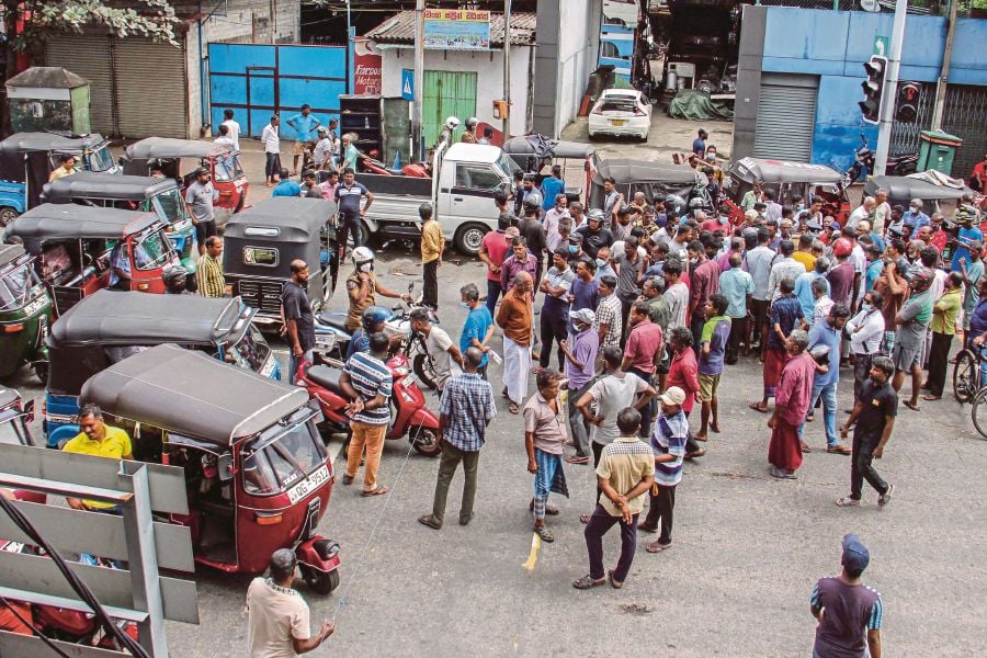 People block a road as they protest against scarcity of fuel near a fuel station in Colombo on June 24, 2022. -AFP PIC