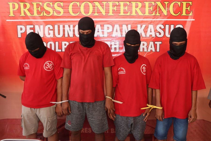 Four Indonesian suspects in connection with the smuggling of Rohingya refugees are seen during a press conference at the West Aceh Police Station in Meulaboh, West Aceh. Four people were arrested in Indonesia in connection with the smuggling of Rohingya refugees last month, police said April 2, who were part of a group whose boat later capsized. - AFP pic