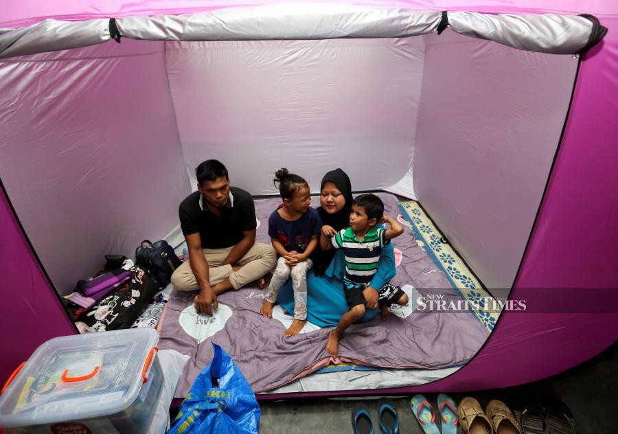 This Dec 28 picture shows a family seeking shelter at Sekolah Menengah Kebangsaan Agama (SMKA) Lati. - NSTP/NIK ABDULLAH NIK OMAR