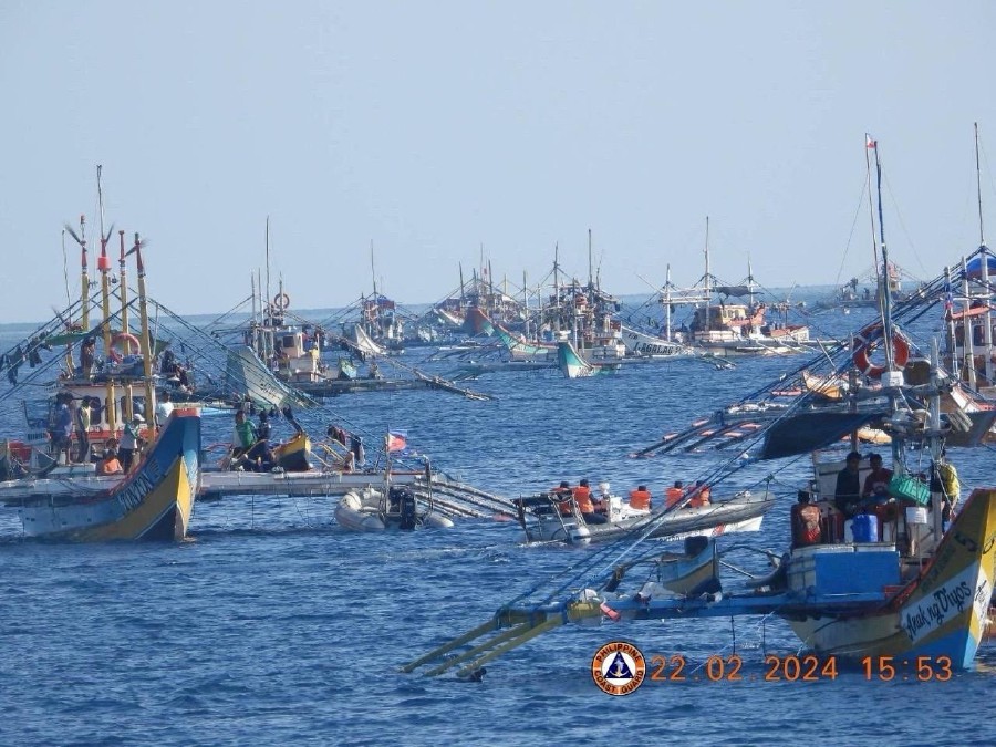This handout photo taken on February 22, 2024 and received on February 25, 2024 from the Philippine Coast Guard shows China Coast Guard personnel onboard a rigid-hulled inflatable boat (centre R) shadowing a Philippine Bureau of Fisheries and Aquatic Resources (BFAR) inflatable boat (centre L) while it delivers supplies to fishermen during a mission led by the BRP Datu Sanday near the China-controlled Scarborough Shoal in the disputed South China Sea. - AFP PIC