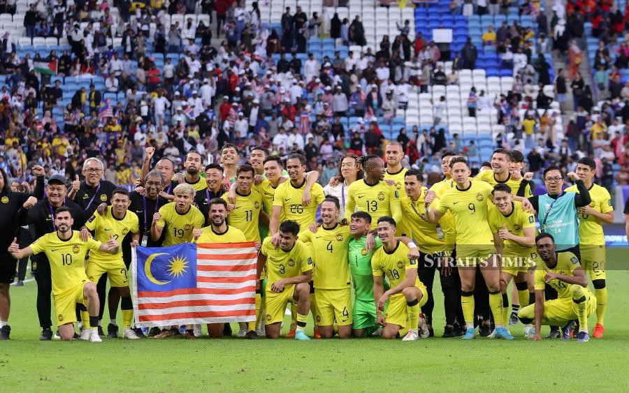 Harimau Malaya players and staff pose for a photo after the match against South Korea at Al Janoub Stadium in Doha. -NSTP/HAIRUL ANUAR RAHIM