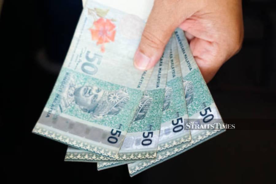 The ringgit opened a tad lower against the US dollar today after the US Federal Reserve (Fed) kept its benchmark interest rate unchanged.