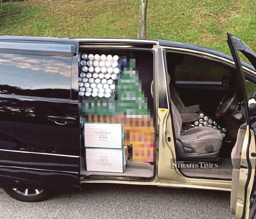 A van laden with crates of duty-free alcoholic beverages waiting to be handed over to a customer outside Forest City. The image, which went viral on social media, was confirmed by police. - NSTP/JASSMINE SHADIQE