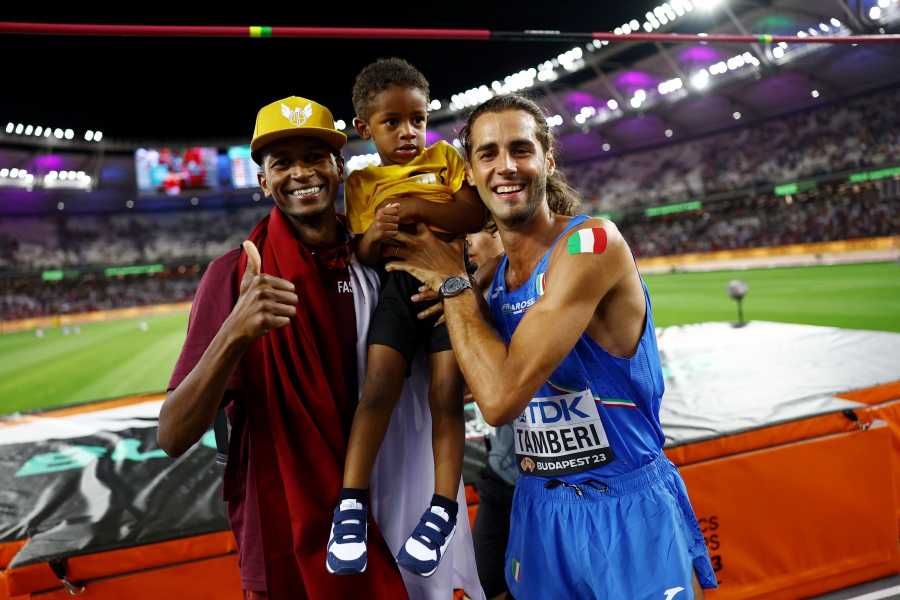 Italy's Gianmarco Tamberi celebrates winning the final alongside bronze medallist Qatar's Mutaz Essa Barshim and a child during the World Athletics Championship, men's high jump event at the National Athletics Centre, Budapest, Hungary, August 22, 2023.- REUTERS PIC