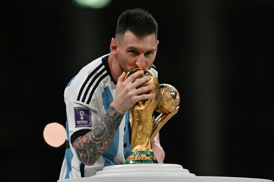 Argentina's captain and forward Lionel Messi kisses the FIFA World Cup Trophy during the trophy ceremony after Argentina won the Qatar 2022 World Cup final football match between Argentina and France at Lusail Stadium in Lusail, north of Doha on December 18, 2022. - AFP PIC