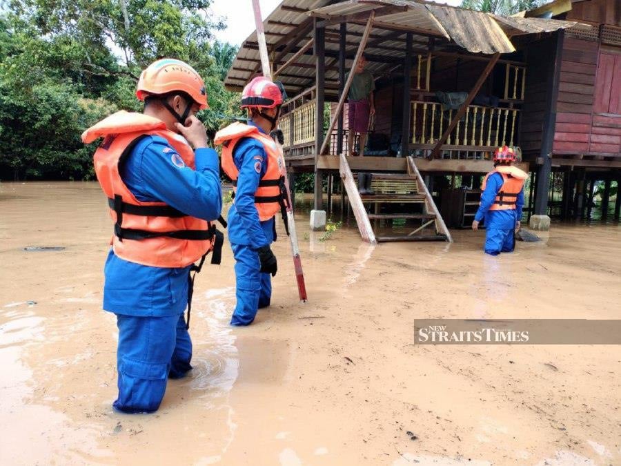  Civil Defence Force personnel help residents evacuate during the floods in Kuala Muda- Pix courtesy of Civil Defence Force