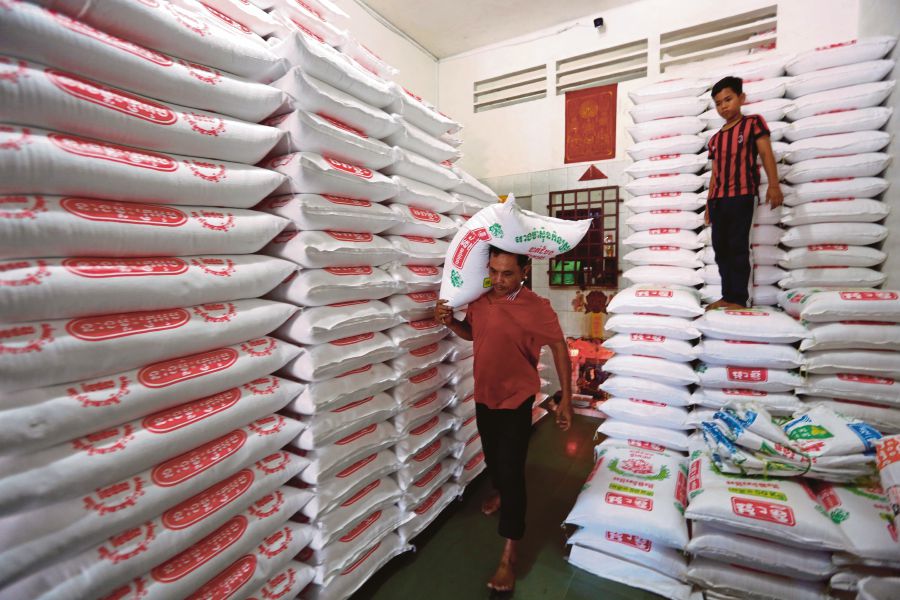 Thai workers prepare rice sacks to be sold at the Department of