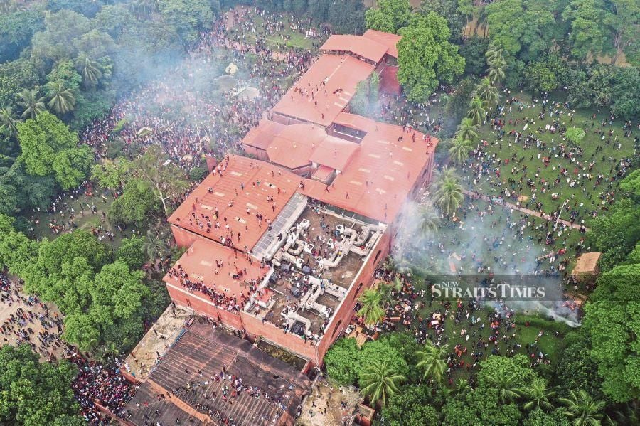 An aerial view shows anti-government protestors storming Bangladesh's ousted Prime Minister Sheikh Hasina's palace in Dhaka on Aug 5, 2024. AFP photo