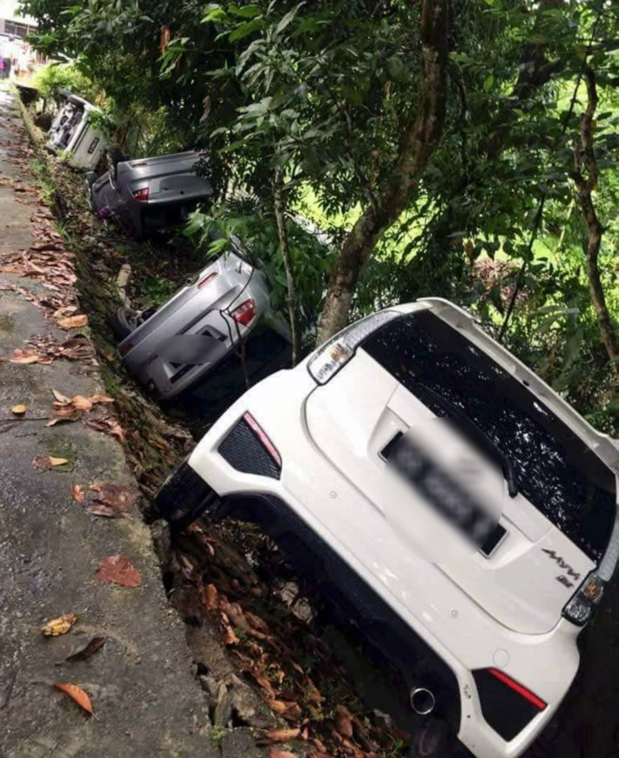 The 9.05am collapse caused four of the cars to tumble down the short hillside, with some of the vehicles landing on their sides or turning turtle. (pix by AWANG ALI OMAR)