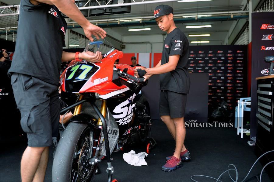 Sepang International Circuit (SIC) Junior Team rider Adam Norrodin takes a closer look at the machine that he will be riding this weekend in the Asian Road Racing Championship (ARRC) at the Sepang Circuit. (PIC BY BERNAMA)