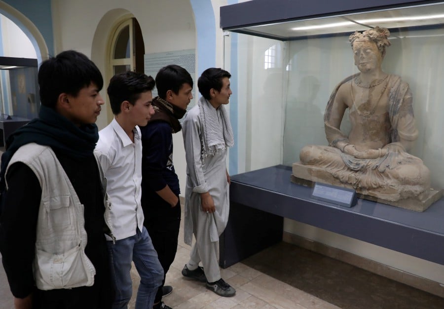 Afghan youth look at a statue that is displayed at the National Museum in Kabul, Afghanistan. -- Reuters photo
