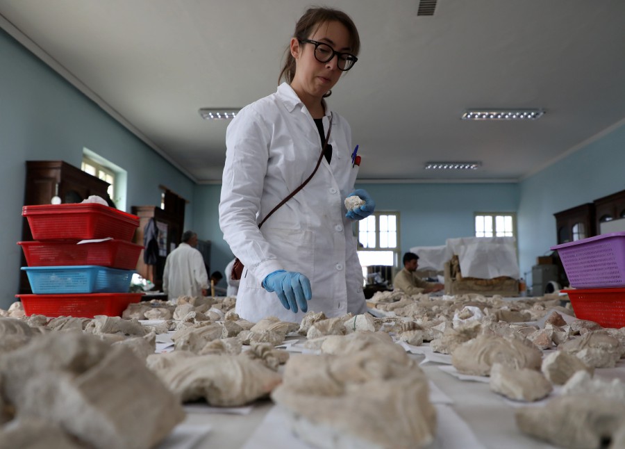 A foreigner conservator works on pieces of statues damaged by the Taliban, in National Museum of Afghanistan in Kabul, Afghanistan. -- Reuters photo