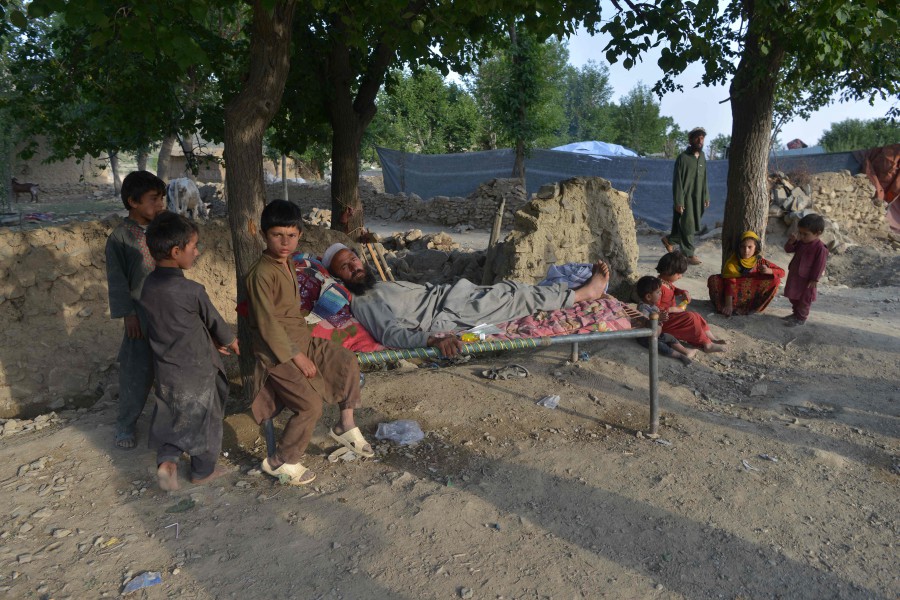 In this photograph taken on June 25, 2022, villagers sit outside their damaged house after a recent earthquake at Akhtar Jan village in Gayan district of Paktika province. - A 5.9-magnitude earthquake rumbled through the area on June 22, killing more than 1,000 people, injuring three times that many, and leaving tens of thousands homeless. - AFP pic
