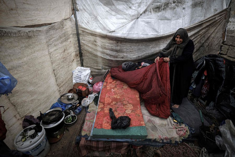 A Palestinian woman arranges a bed in a tent at a makeshift camp housing displaced Palestinians, in Rafah in the southern Gaza Strip, amid the ongoing conflict between Israel and the militant group Hamas, on January 2, 2024. - AFP pic