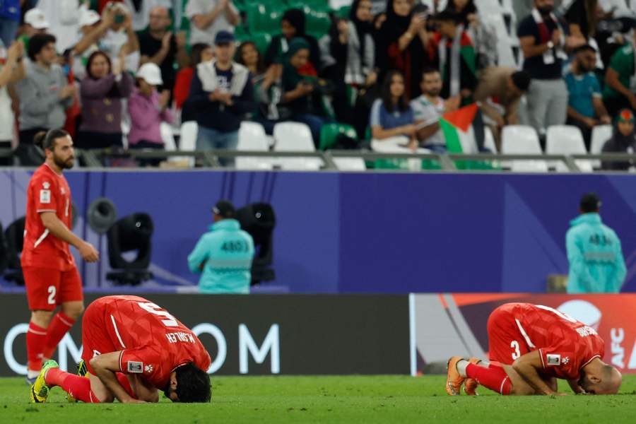 Palestine's midfielder #03 Mohammed Rashid and Palestine's defender #05 Mohammed Saleh bow in prayer after the Qatar 2023 AFC Asian Cup Group C football match between Iran and Palestine on January 14, 2024. - AFP pic