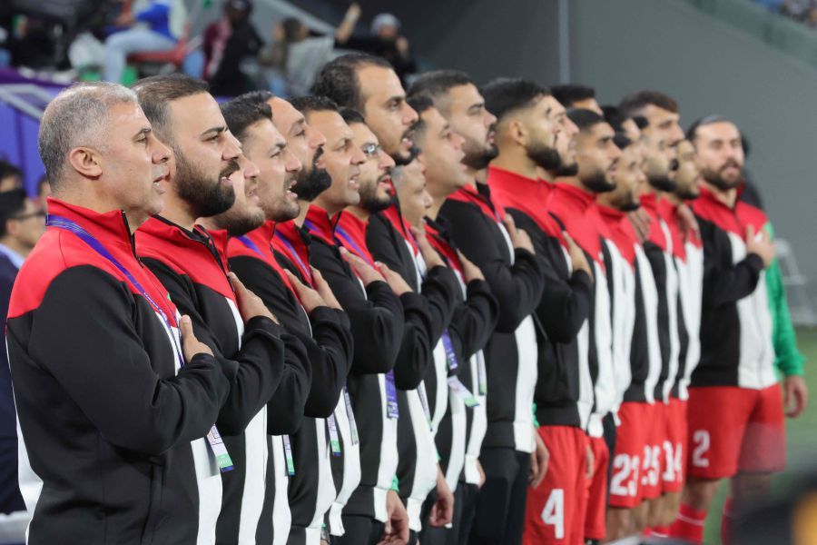 Palestine's Tunisian coach Makram Daboub (L) and his staff stand up for their national anthem before the start of the Qatar 2023 AFC Asian Cup Group C football match between Palestine and United Arab Emirateson January 18, 2024.- AFP pic
