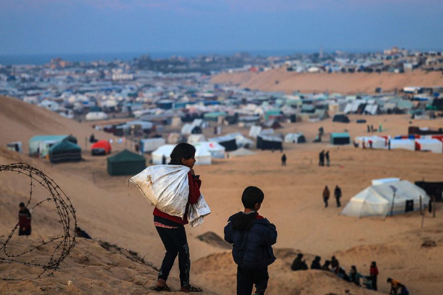 Displaced Palestinian children walk on a hill facing their makeshift camp in Rafah, on the southern Gaza Strip on the border with Egypt on January 19, 2024. - AFP pic