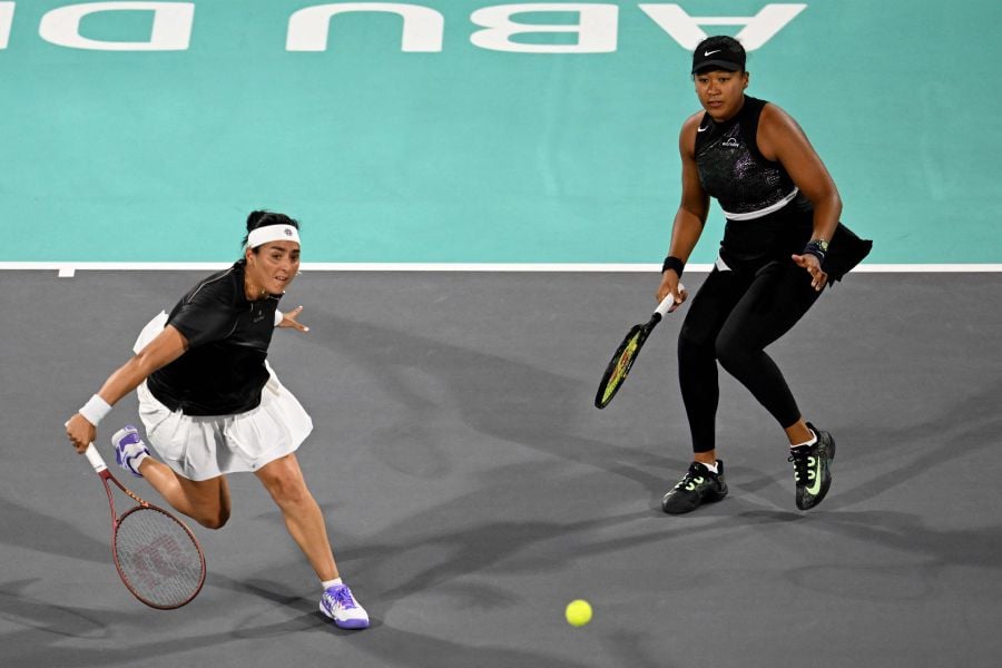 Tunisia's Ons Jabeur (L) hits a return next to teammate Japan's Naomi Osaka during the women’s doubles match against Poland's Magda Linette and Bernanda Pera of the US at the Mubadala Abu Dhabi Open tennis tournament in Abu Dhabi on February 6, 2024. - AFP pic