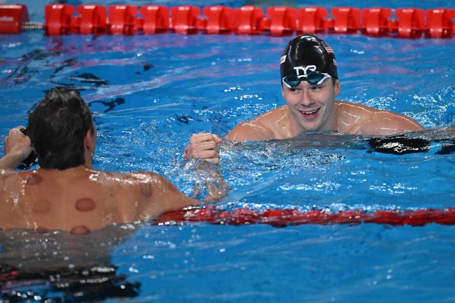 US' Nic Fink (R) is congratulated by Italy's Nicolo Martinenghi after he won the final of the men's 100m breaststroke swimming event during the 2024 World Aquatics Championships at Aspire Dome in Doha on February 12, 2024.- AFP pic