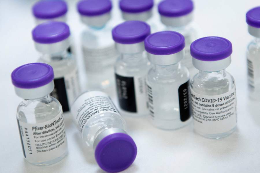 (FILES) In this file photo taken on December 30, 2020, vials of Pfizer-BioNTech Covid-19 vaccine are prepared to administer to staff and residents at the Goodwin House Bailey's Crossroads, a senior living community in Falls Church, Virginia. - Pfizer and BioNTech said on February 25, 2021, they are studying adding a third dose to their vaccine regime and testing a new version targeting the South African variant of the coronavirus. In one study, the US and German pharmaceutical firms said they would look at what happens when people are given a third dose of their two-shot vaccine, six to 12 months after the booster. (Photo by Brendan Smialowski / AFP)