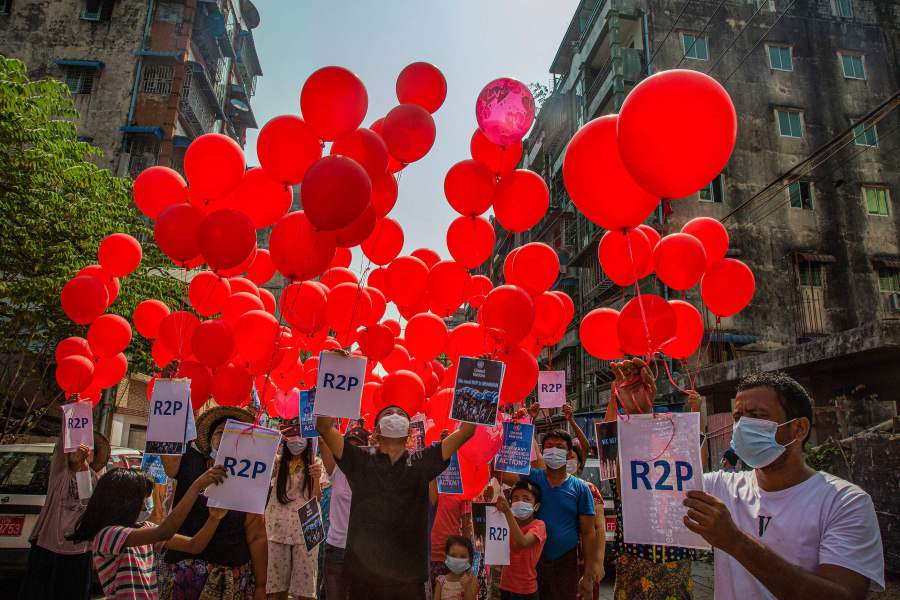 This photo taken and received courtesy of an anonymous source via Facebook on March 22, 2021 shows residents preparing to set free balloons with messages relating to "R2P", or the "Responsibility to Protect" principle that the international community is justified in taking action against a state that is deemed to have failed to protect its population from atrocities, in Yangon's Hlaing township, as security forces continue to crackdown on demonstrations by protesters against the military coup. (Photo by Handout / FACEBOOK / AFP) 