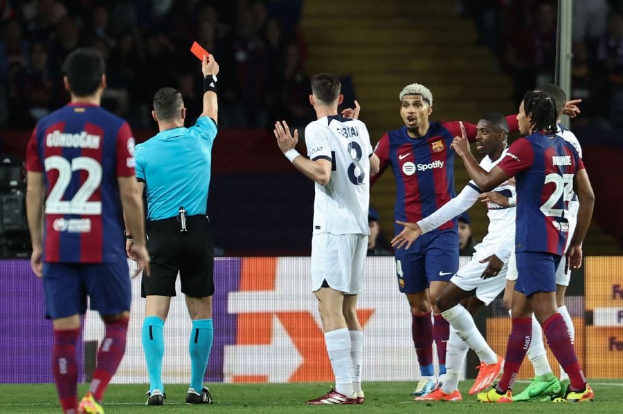 Romanian referee Istvan Kovacs gives a red card to Barcelona's Uruguayan defender #04 Ronald Araujo during the UEFA Champions League quarter-final second leg football match between FC Barcelona and Paris SG at the Estadi Olimpic Lluis Companys in Barcelona on April 16, 2024. - AFP Pic