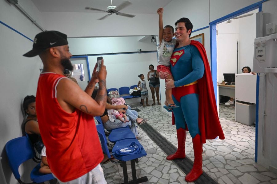 Leonardo Muylaert, 36, known as the Brazilian Superman, poses with a boy at the Association of Parents and Friends of Neurodivergent People (APAE-RIO) in the Tijuca neighborhood in Rio de Janeiro, Brazil, on March 18, 2024. - AFP pic