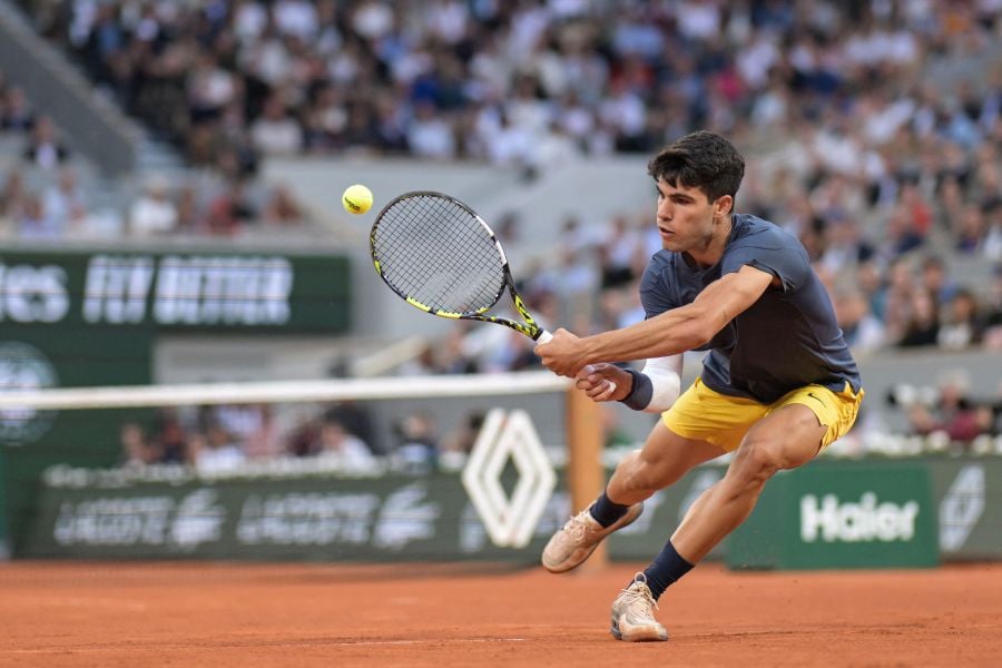 Spain's Carlos Alcaraz Garfia plays a backhand return to Greece's Stefanos Tsitsipas during their men's singles quarter final match on Court Philippe-Chatrier on day ten of the French Open tennis tournament at the Roland Garros Complex in Paris on June 4, 2024.- AFP PIC