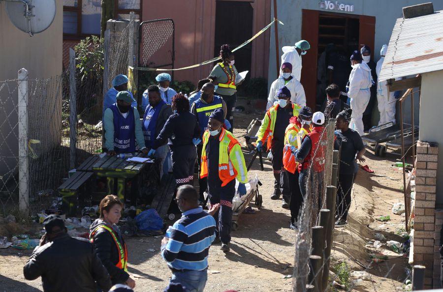 Forensic personel carry a body out of a township pub in South Africa's southern city of East London on June 26, 2022, after 20 teenagers died. - AFP Pic