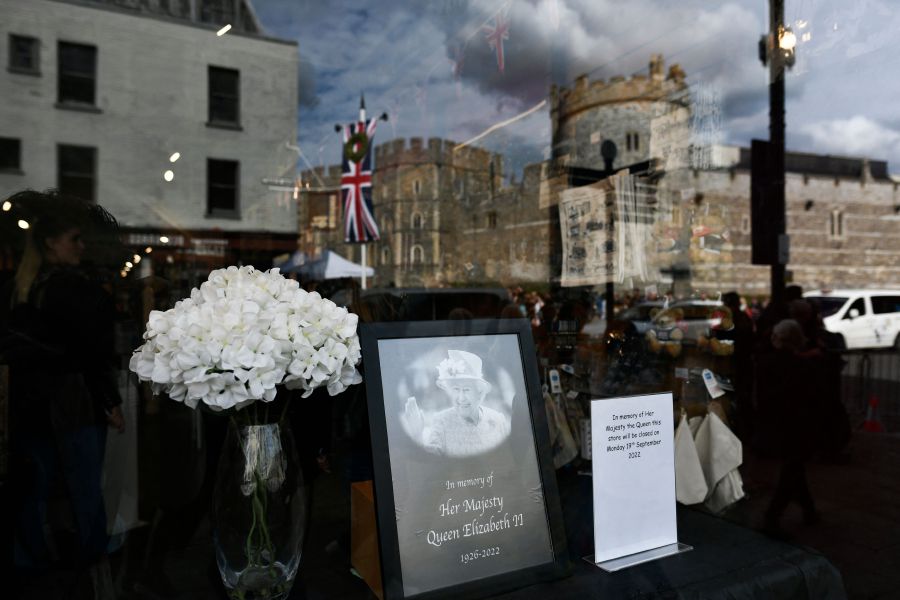 Windsor Castle is refelcted on a portrait of Britain's Queen Elizabeth II that is displayed in a window in Windsor. - AFP Pic