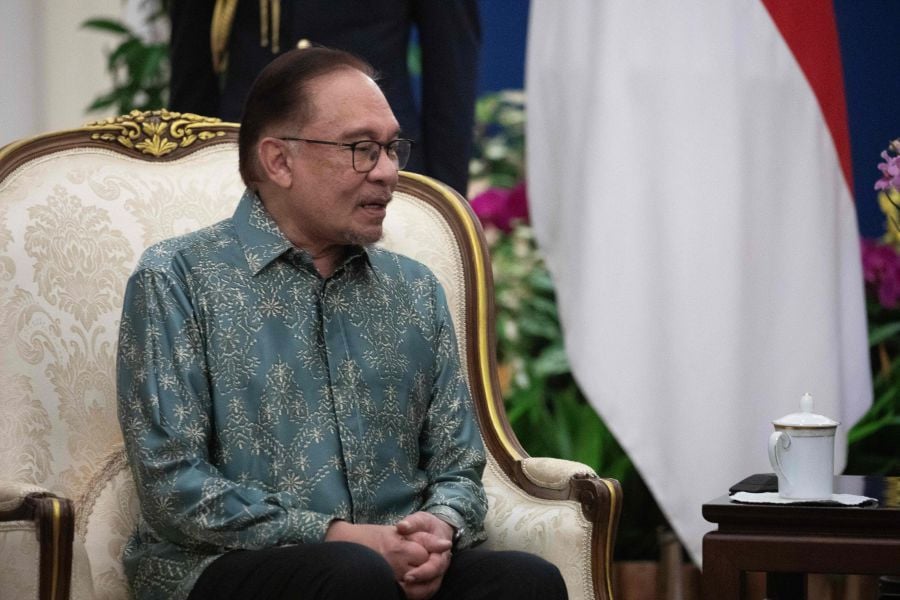 Malaysia's Prime Minister Anwar Ibrahim chats with Singapore's President Tharman Shanmugaratnam (not pictured) during their meeting at the Istana or Presidential Palace in Singapore on October 30, 2023. - AFP Pic