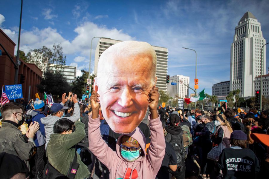 A woman holds a Joe Biden mask as people march in Los Angeles celebrating after Joe Biden was declared the winner of the 2020 presidential election. - AFP pic