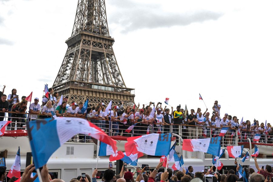 (FILES) Jamaican sprinter Usain Bolt (C-R) holds the Olympic torch, flanked by President of the Paris 2024 Organising Committee Tony Estanguet during the torch's presentation on the river Seine, as the landmark Eiffel Tower is seen in background, in Paris, on July 25, 2023, ahead of the Paris 2024 Olympic and Paralympic Games. - AFP pic