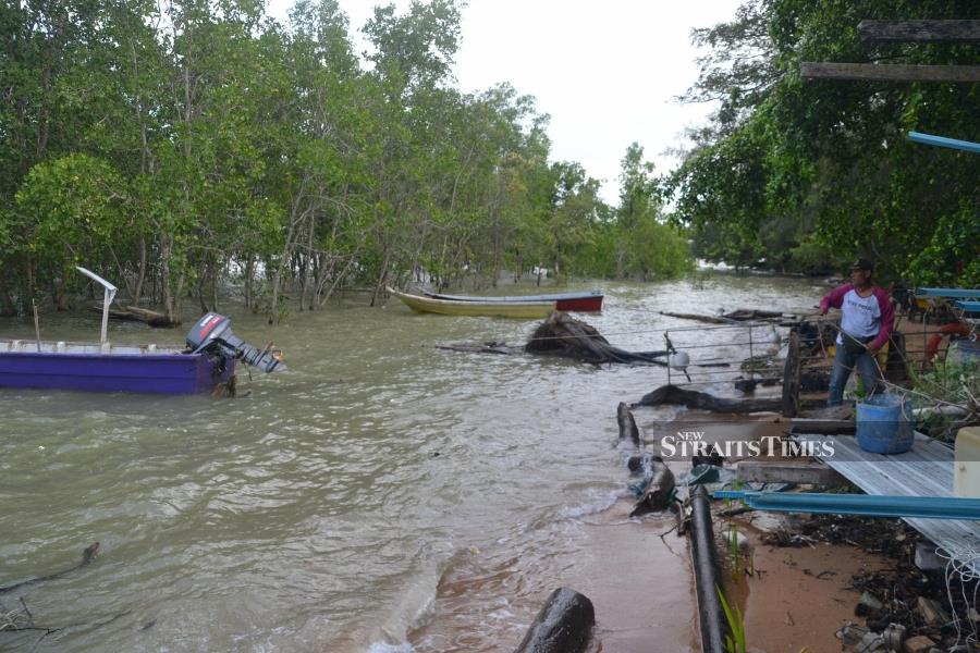 The natural phenomenon brought to halt the movement of traders in Kuala Sungai Baru, as well as kept fishermen in Kuala Linggi from going out to sea. - NSTP/HASSAN OMAR 